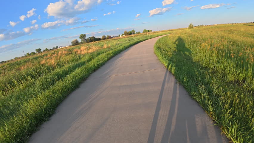 First person POV from bike riding in springtime scenery on the Poudre River Trail across prairier near Timnath, Colorado