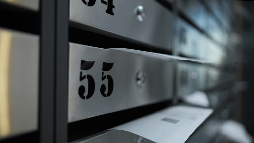 Utility bill partially inserted in apartment mailbox