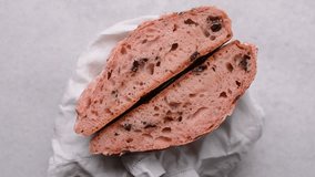 Overhead view of sliced strawberry and chocolate sourdough bread, top view of pink and chocolate artisan bread on a white parchment paper, open crumb pink artisan bread on white background - Powered by Shutterstock - Get 15% off with code: PIKWIZARD15