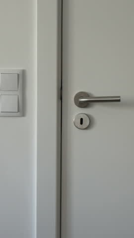 Hand opens and closes white door to storage room or utility room, minimalist interior scene, close-up. Everyday momemts lifestyle, vertical