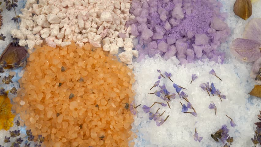 Aromatic relaxing herbal and floral sea bath salt, various dried plants for making aromatic salt are on a blue background, top view