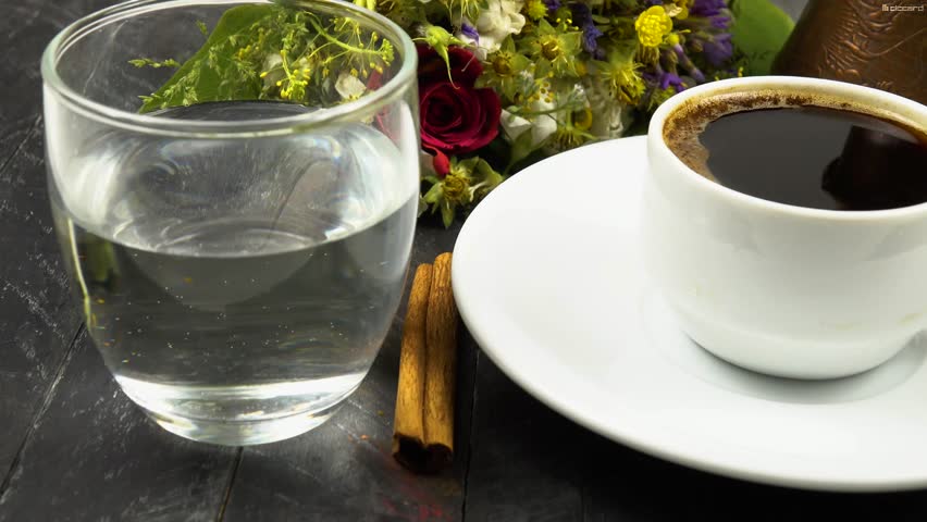 Coffee in a cezve and in a cup of coffee, a glass of water, coffee beans, salt, cinnamon. Coffee and various additions to it