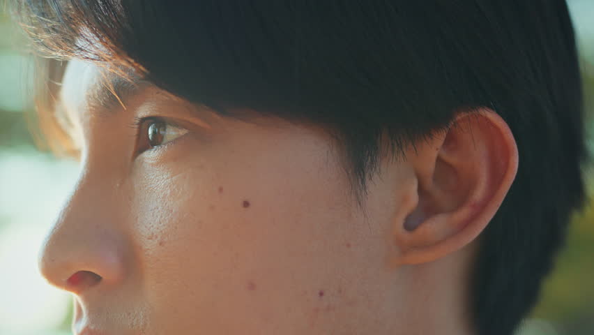 Close-up of asian man’s eye opening and focusing straight ahead with determination – thoughtful moment before morning run in public park, mental focus, motivation, and fitness goal mindset