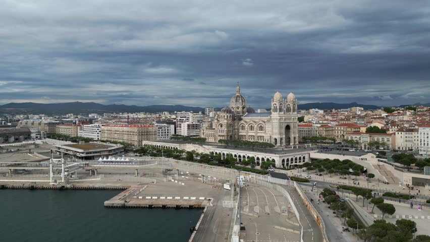 Aerial view of Marseille, France, showcasing the port, the impressive Cathédrale La Major. The scene captures urban architecture and coastal landscape. High-end travel commercials, European tourism