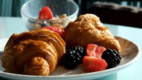 Vertical screen: pouring fruit topping on a fresh croissant in a plate. Drizzle liquid caramel over a freshly baked croissant topped with ripe berries. A nutritious breakfast or snack at work. - Powered by Shutterstock - Get 15% off with code: PIKWIZARD15
