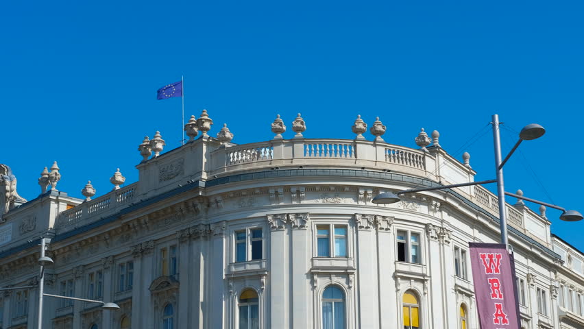 Griffin statue guarding austrian parliament building. Bronze griffin statue perched atop a plinth, with austrian parliament building in the background, showcases vienna