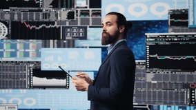 Professional businessman analyzing info and finance charts on digital dashboard, ensuring strategic planning with infographics on tablet. Leadership in fast paced corporate economy. Camera B. - Powered by Shutterstock - Get 15% off with code: PIKWIZARD15