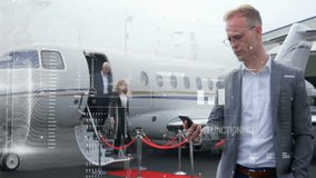 Male executive checking smartphone starting business overlay, team descending jet stairs red carpet. Corporate, professionalism, technology, travel, leadership, innovation, communication - Powered by Shutterstock - Get 15% off with code: PIKWIZARD15