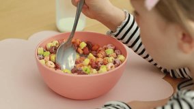 Child enjoying breakfast with colourful cereal in a sunny kitchen setting. Concept of dry breakfast. - Powered by Shutterstock - Get 15% off with code: PIKWIZARD15