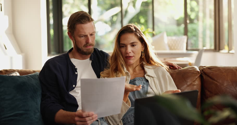Frustrated couple, documents or stress with laptop on sofa for financial crisis, bankruptcy or debt. Upset, woman and man with paperwork or computer for poor finance, bad investment or tax inflation