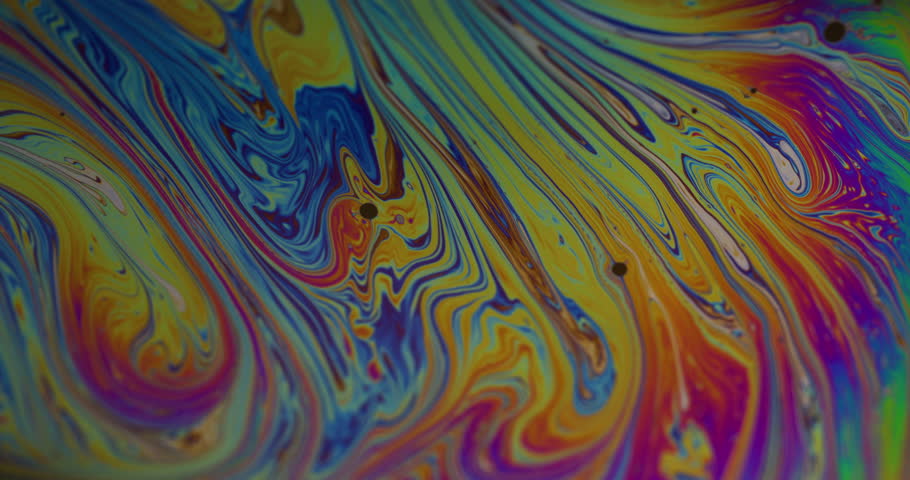 Psychedelic art. Oil fluid mix. Defocused blue yellow purple colorful flowing paint liquid droplet floating on abstract background.