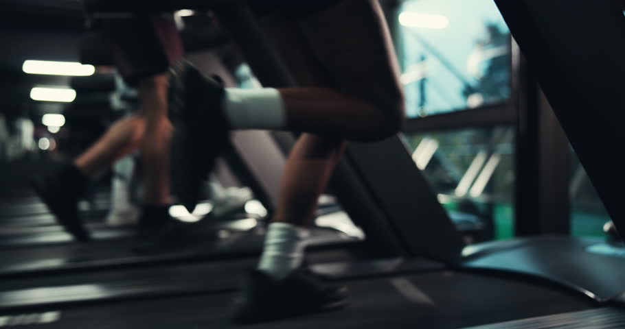 Woman, running and treadmill in gym with legs, athlete training and endurance for health. Cardio, exercise equipment or machine with female runner, intense and action for wellness at fitness center