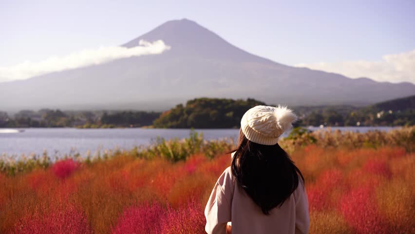 Young female tourist relaxing and enjoying at beautiful landscape mount Fuji at Kawaguchiko Lake