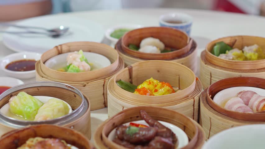 Young woman traveler eating traditional Chinese Dim Sum at restaurant