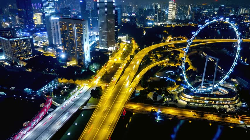 Night View of Singapore Cityscape with Illuminated Roads and Ferris Wheel