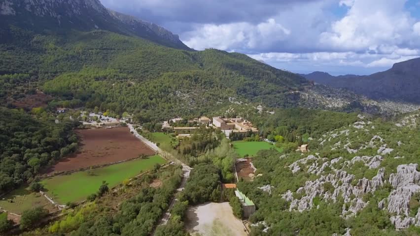 Aerial View of Serene Mountain Valley Landscape with Farmland and Winding Road