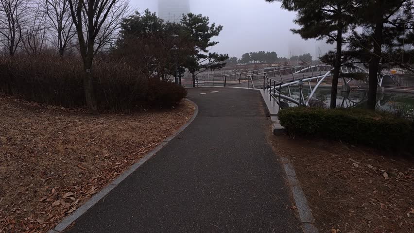 Walking On The Pathway Towards The Pedestrian Bridge In Songdo Central Park, Incheon, South Korea. POV Shot