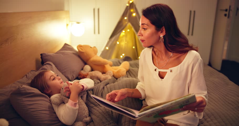 Reading, book and mother with child in bedroom for bedtime story, night and bonding. Support, storytelling and fairytale with woman and kid in family home for love, teaching and learning together