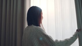 Happy young asian woman smiling and opening curtains to let morning sunlight into the room – fresh new day, hope, positive mindset and peaceful lifestyle at home with natural light and bright energy - Powered by Shutterstock - Get 15% off with code: PIKWIZARD15