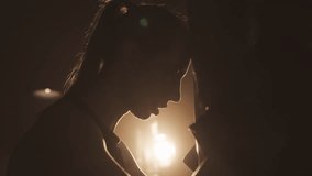 Exhausted female fighter leaning on punch bag in gym, silhouette in dark ring. Tired athletic woman breathing hard after intense cardio workout, female beauty and power, self-defense classes for women - Powered by Shutterstock - Get 15% off with code: PIKWIZARD15