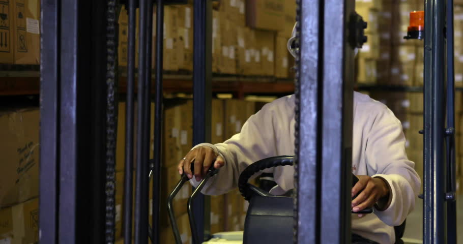 Forklift operator steering forklift in warehouse, initiating world map displaying logistics data. Industrial, logistics, technology, transportation, data, warehouse, automation
