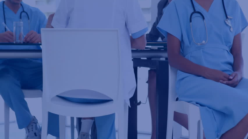Nurse smiling at camera as medical team gathering around table, analyzing data tickers and charts. Collaboration, healthcare, analytics, teamwork, professionalism, innovation, data visualization - Powered by Shutterstock - Get 15% off with code: PIKWIZARD15