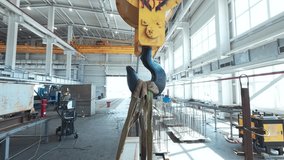 Hook of traveling gantry crane inside of industrial metalwork workshop. Handheld real time footage - Powered by Shutterstock - Get 15% off with code: PIKWIZARD15