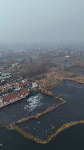 Vertical drone showcasing the silent beauty of frozen Dal Lake under the winter chill of Srinagar.