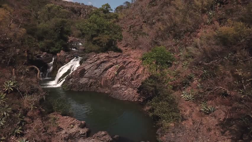view of a waterfall over red rocks