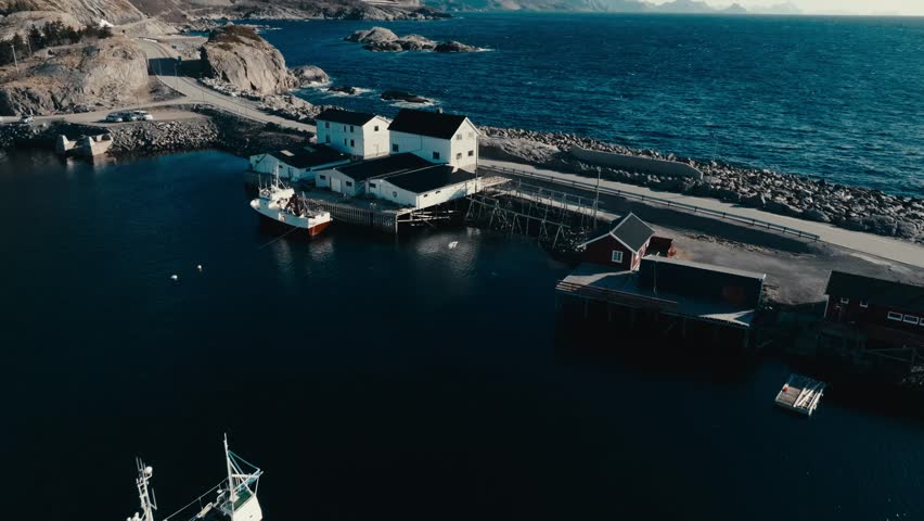 Coastal Road, Boathouse And Fishing Boat In Reine, Norway. - aerial shot