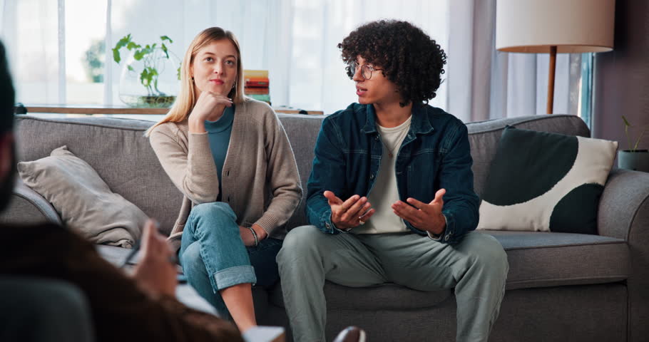 Therapy, angry and couple on sofa talking for relationship help, counseling and partnership issue. Psychology, upset and man with woman in discussion, argument and conflict for emotional burnout