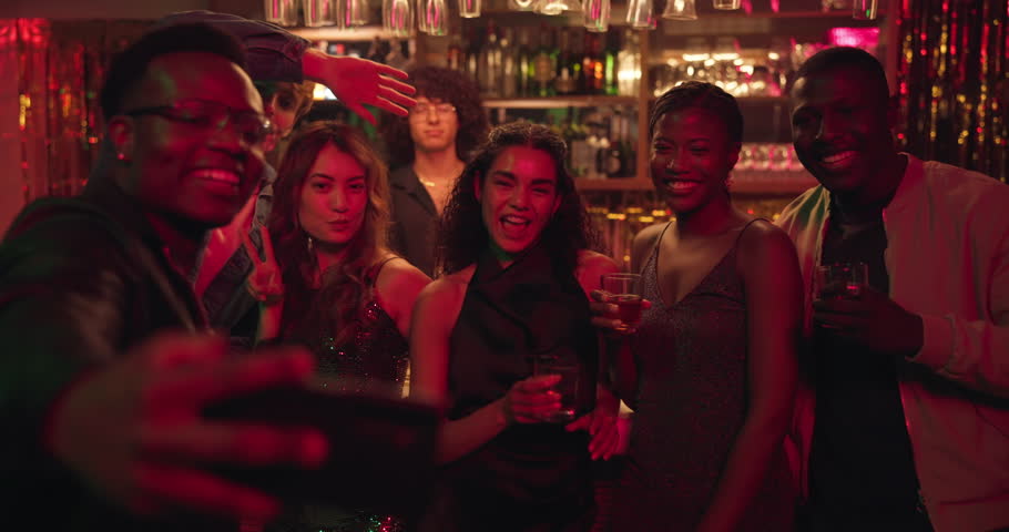 Selfie, cocktails and group of friends in club, party or social event at night for fun together. Smile, cheers and people with alcohol drinks at happy hour for photography picture for memory in pub.