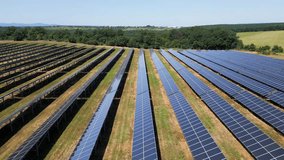 Aerial view of a large solar power plant with rows of photovoltaic panels installed on open land, generating clean renewable energy under a clear sky - Powered by Shutterstock - Get 15% off with code: PIKWIZARD15