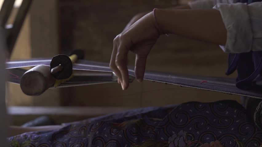 Close-up of a woman's hands weaving traditional cloth