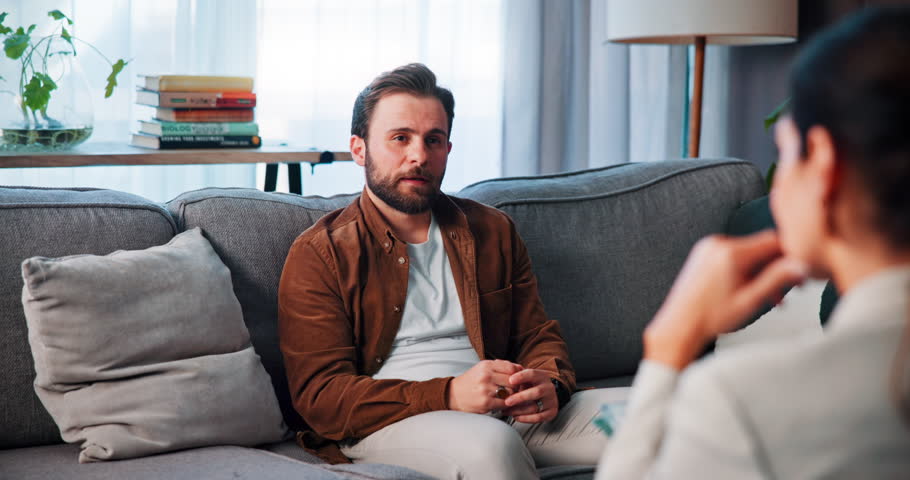 Counseling, listening and man with therapist on sofa for consulting, emotional support and help. Psychology, mental health and person with patient talking for therapy session, diagnosis or evaluation