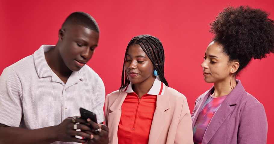 Friends, group and phone with laughing in studio with smile, meme or funny video by red background. African people, man and women with smartphone, joke and mobile app for sharing post on social media