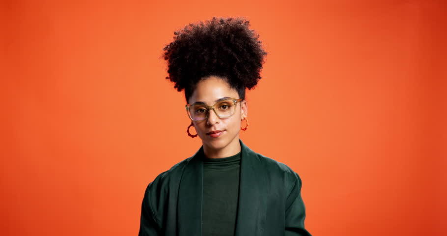 Face, peace sign and smile with black woman on wall background as social media influencer. Afro, emoji reaction and glasses with happy African person in orange studio for post as content creator
