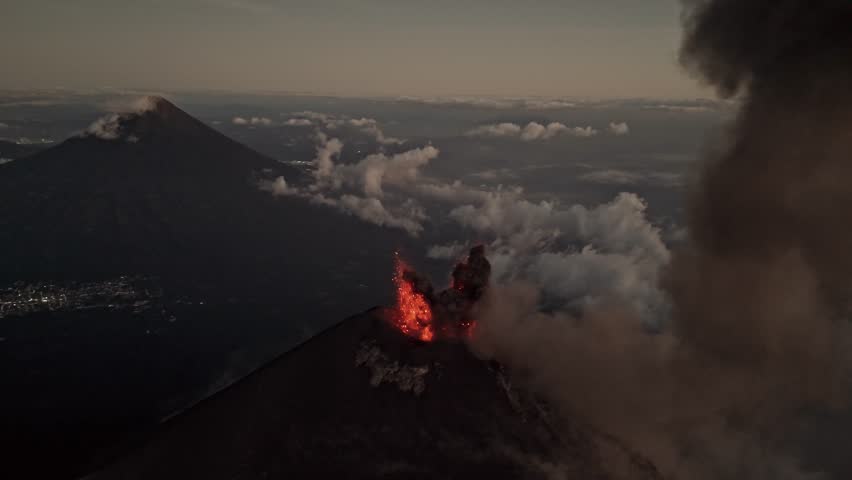 Lava explodes from Fuego volcano, aerial orbit view