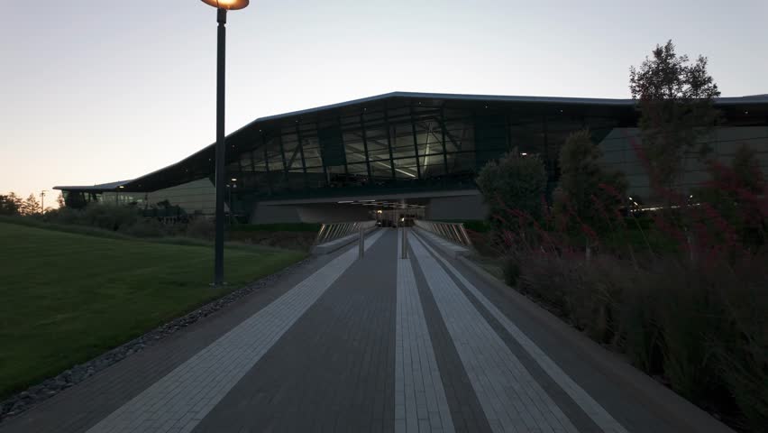 Gimbal wide moving shot approaching the cutting edge Endeavor Building on the Nvidia campus at sunset in Silicon Valley, California. 4K