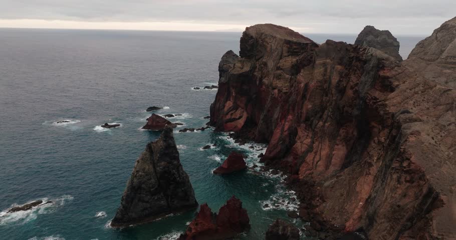 Aerial view of dramatic red cliffs and ocean rock formations along Ponta de São Lourenço, Madeira, Portugal.