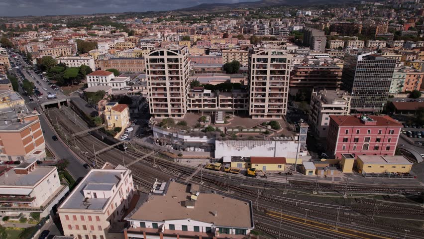 view of a dense urban environment, characterized by a mix of residential and commercial buildings, and a significant railway infrastructure.
