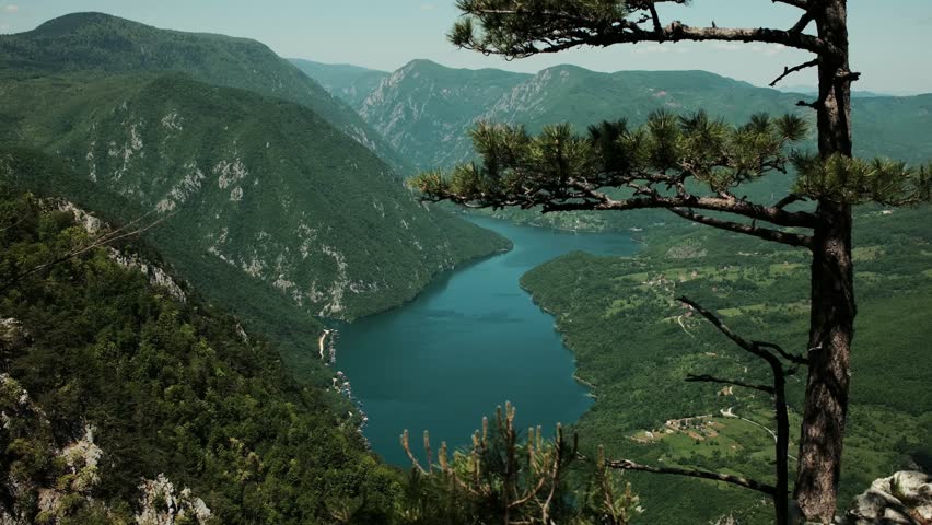 View of the winding Drina River between lush green mountains in Tara National Park, Serbia. Perucac - Peruchac lake. Banjska Stena viewpoint. 4k horizontal footage