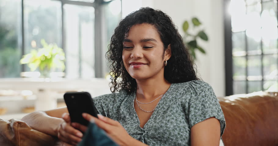 Girl, relax or laughing with phone in home for social media post, online gossip or internet scroll. Happy, person and smartphone on sofa for dating site joke, reading comedy ebook and weekend break