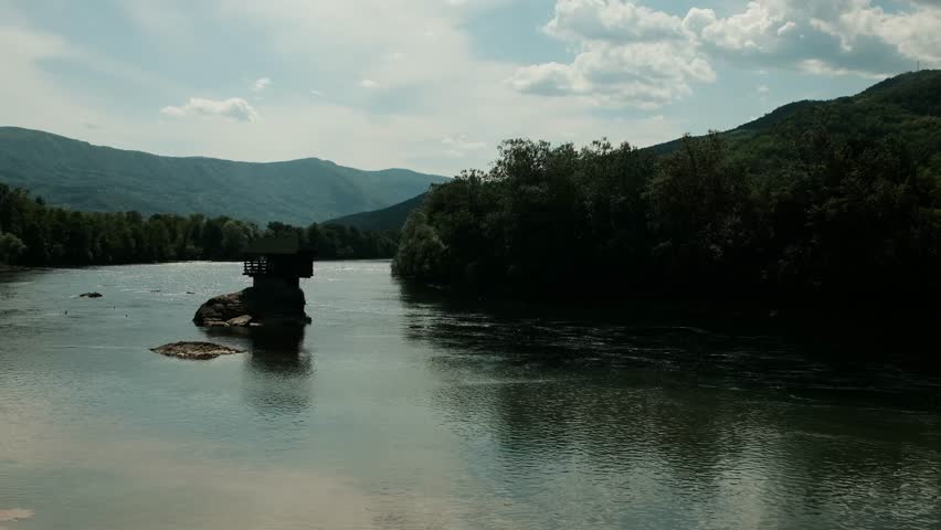 Peaceful view of the famous Drina River house perched on a rock, surrounded by forest and mountains. Serbia country in spring season
