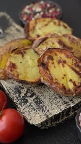 Food, potatoes cut in halves or slices grilled. Cooked baked potatoes with salt and spices