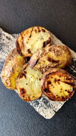 Food, potatoes cut in halves or slices grilled. Cooked baked potatoes with salt and spices
