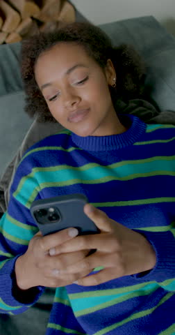 Young Afro American Woman Using Phone on a Comfortable Couch