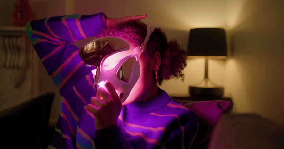 Woman holding a LED Light Mask at Home