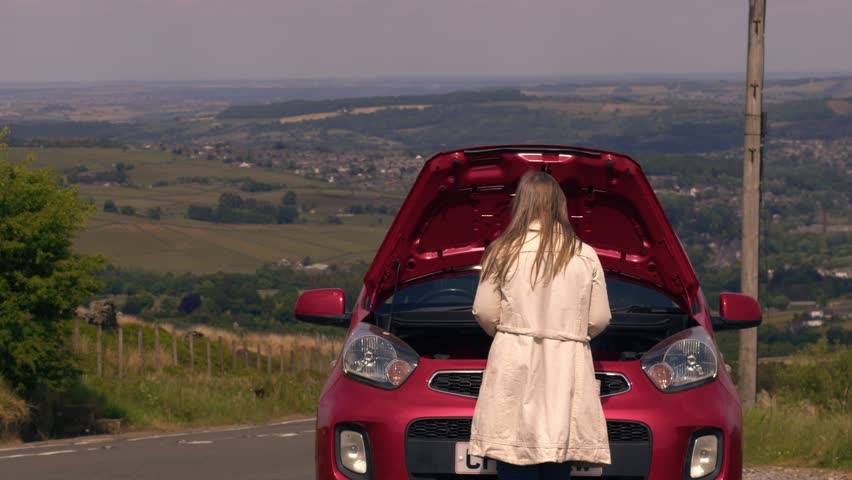 Woman with broken down car with smoke coming out of engine medium 4k shot selective focus