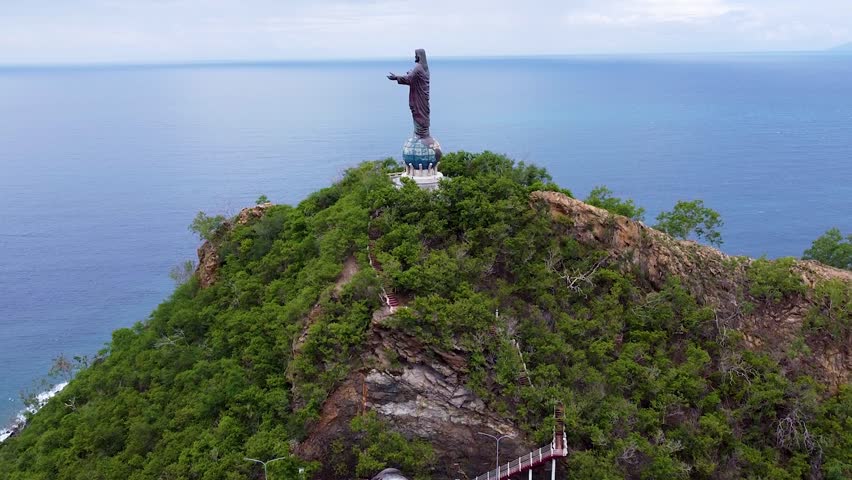 Aerial view rising of Cristo Rei statue landmark overlooking ocean in capital city Dili, Timor-Leste, Southeast Asia